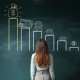 Image: Businesswoman looking at a financial chart on chalkboard