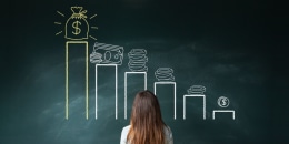 Image: Businesswoman looking at a financial chart on chalkboard