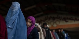 Image: Woman and child queue to receive cash at a money distribution site organized by the World Food Program in Kabul, Afghanistan, on Nov. 20, 2021.