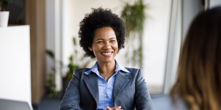 Two diverse businesswomen talking working together in office