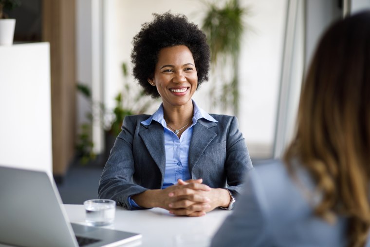 Two diverse businesswomen talking working together in office