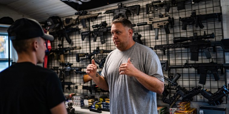 Nate Maillet, right, the owner of First Due Firearms, helps a first buyer customer in Sabattus, Maine